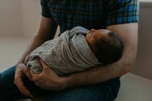 Swaddled newborn with parent
